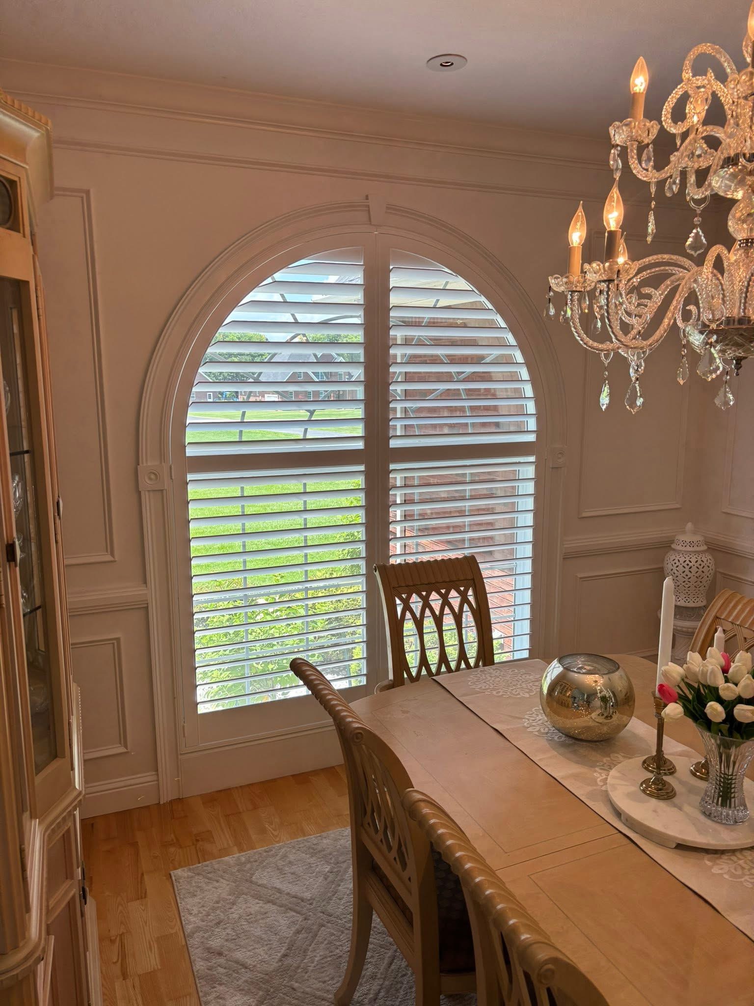 White shutters fitted to an arched dining room window