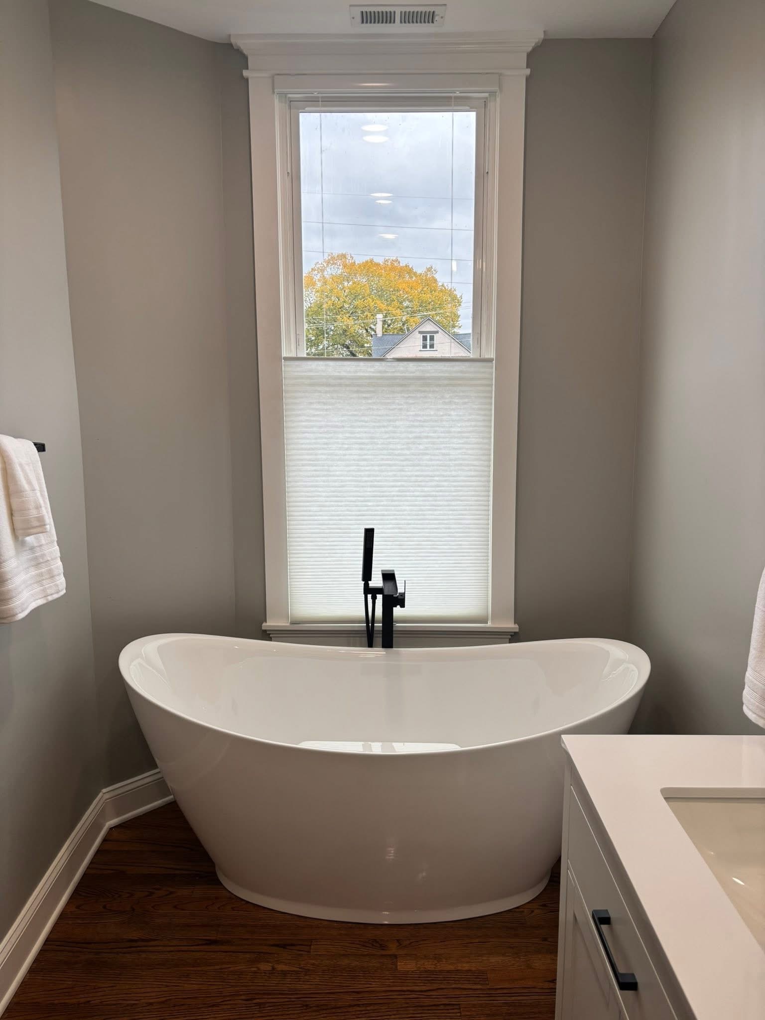 Light-filtering shade above a freestanding bathtub